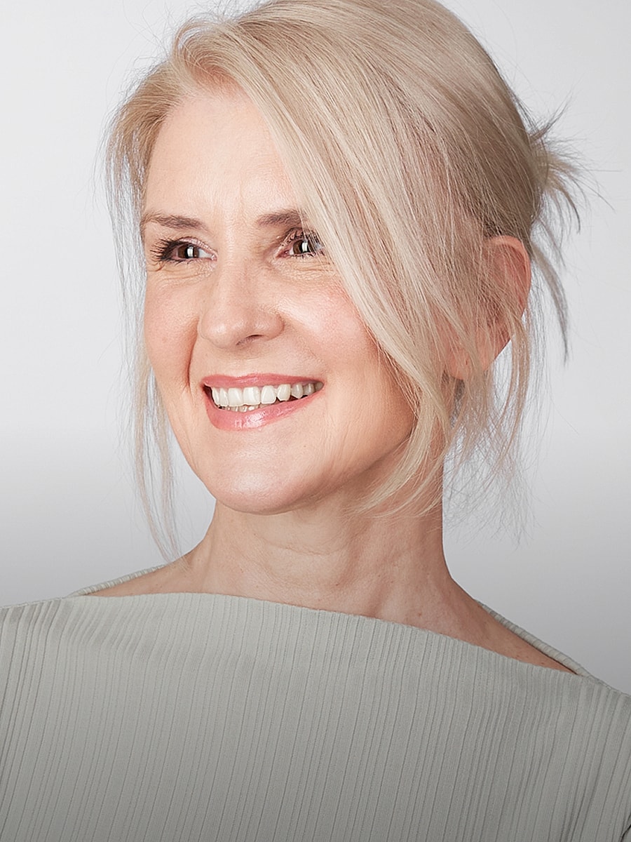 Smiling woman with light blonde hair and soft makeup.