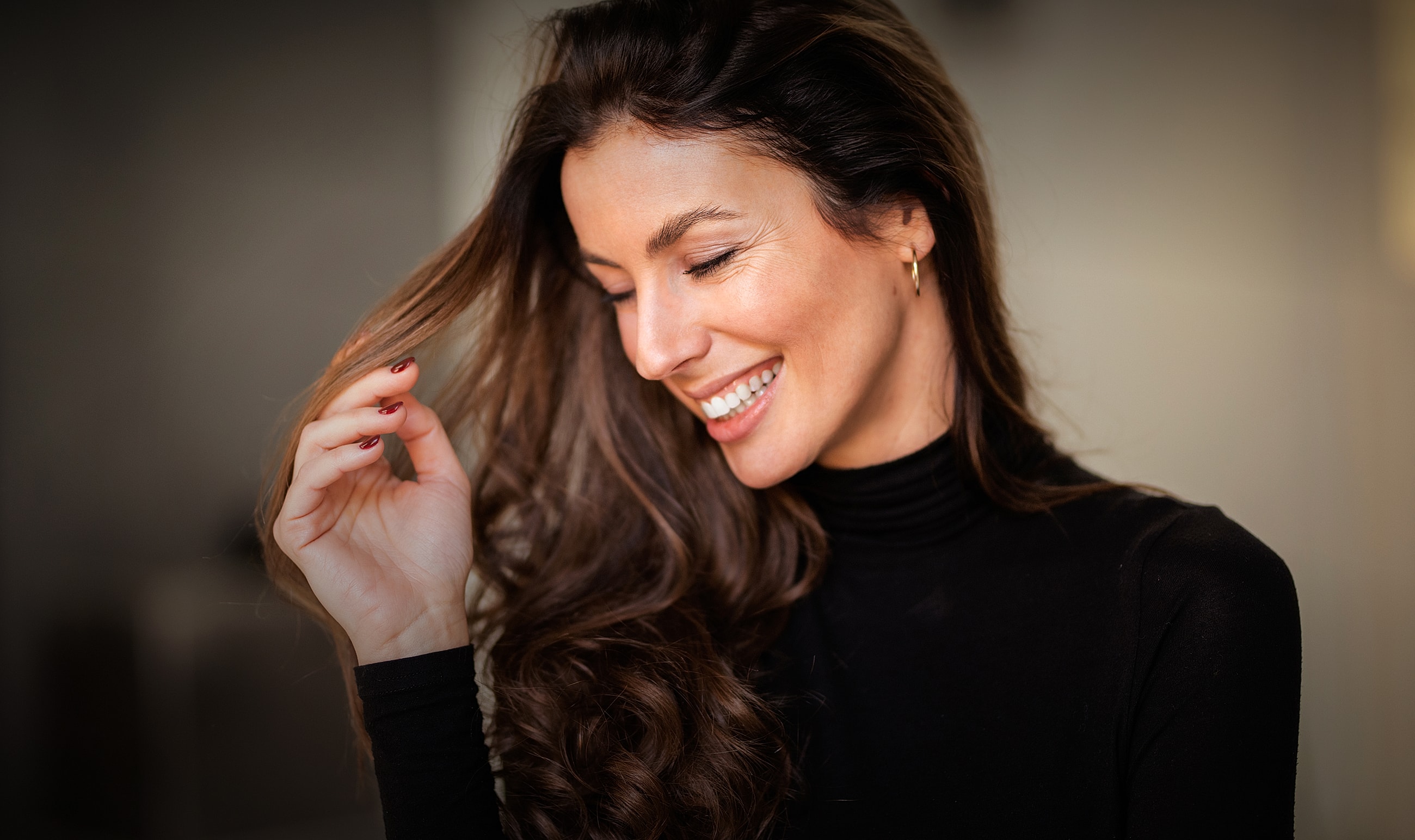Smiling woman touching her hair.